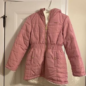 A woman’s DKNY hooded pink winter jacket with ivory faux fur lined inside.